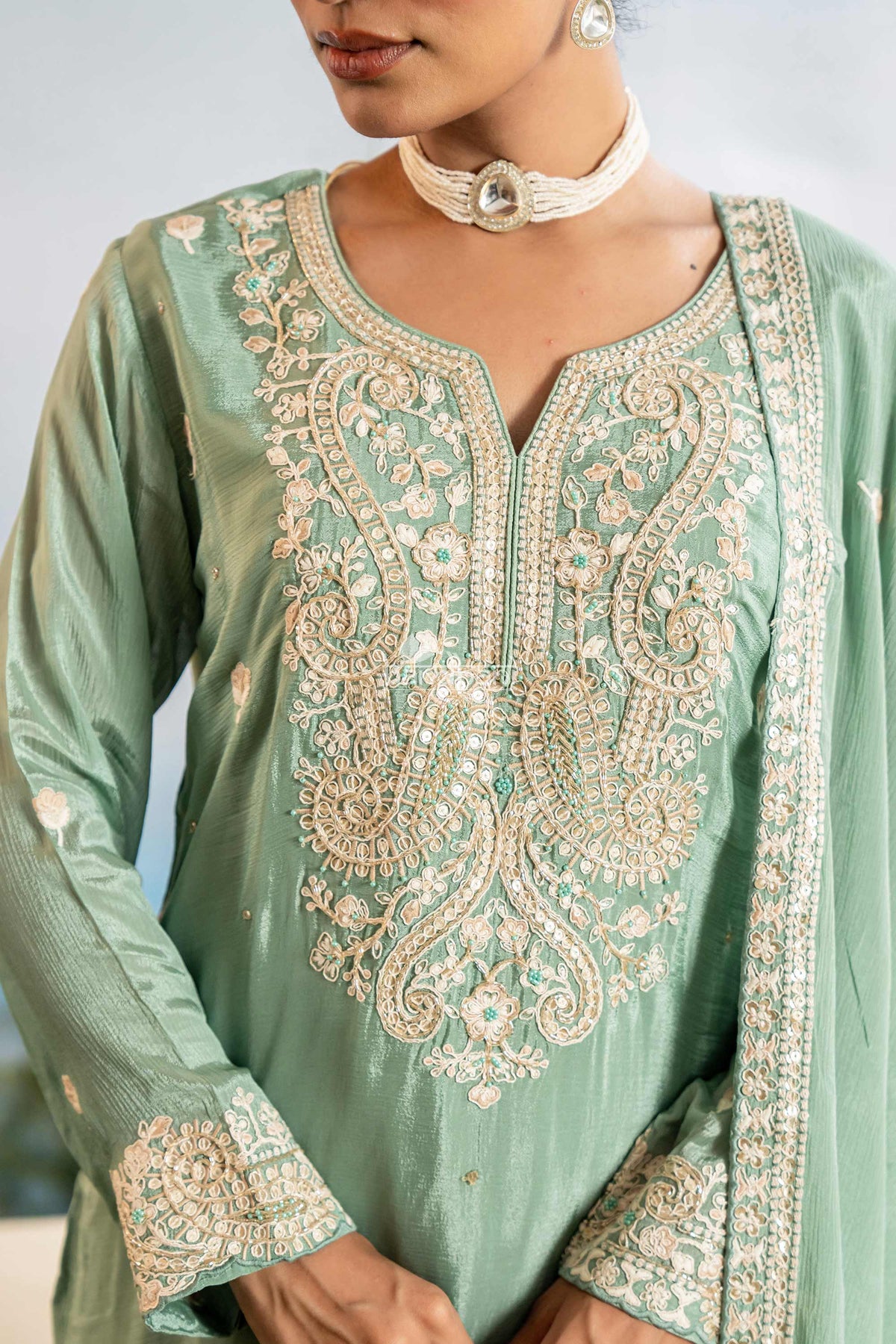 Green embroidered traditional outfit with intricate patterns