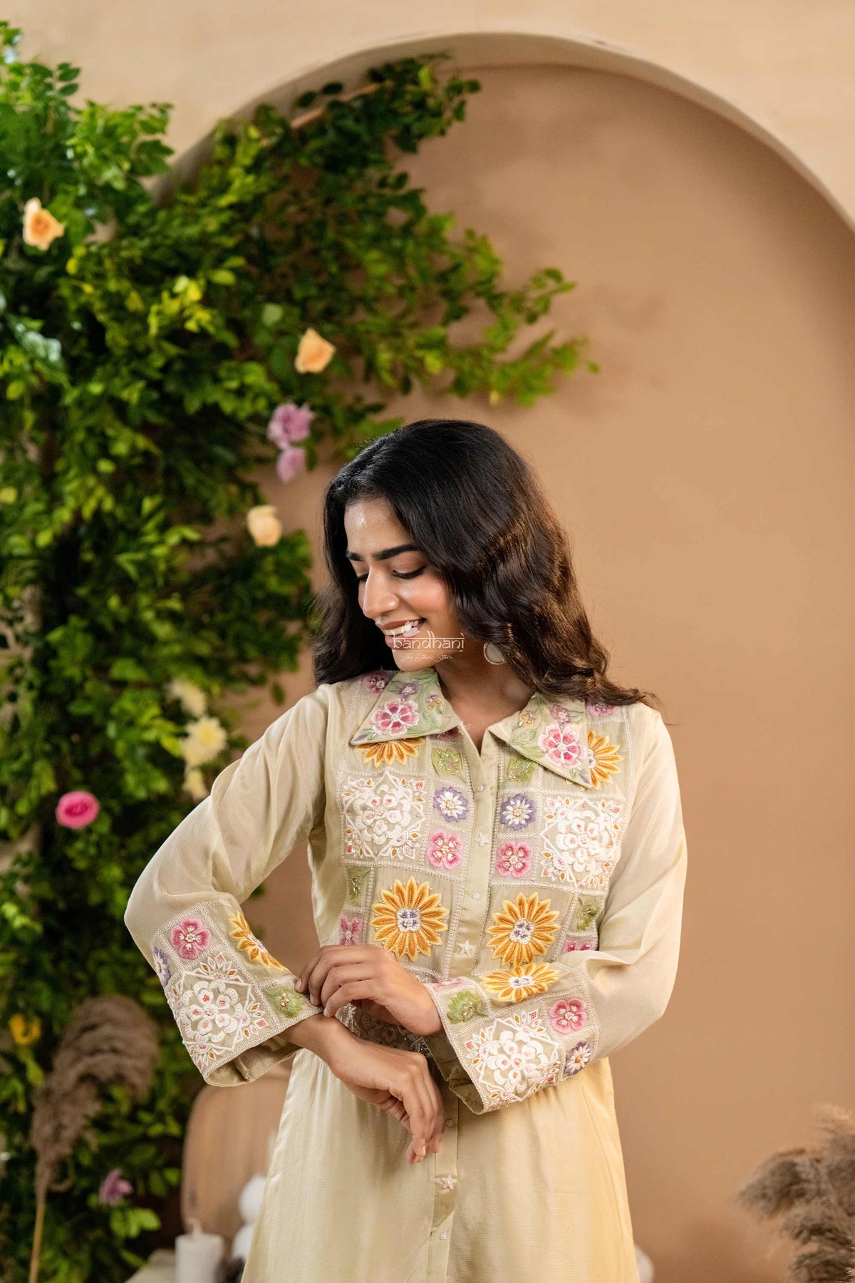 Woman wearing a floral embroidered co-ord outfit with a beige background