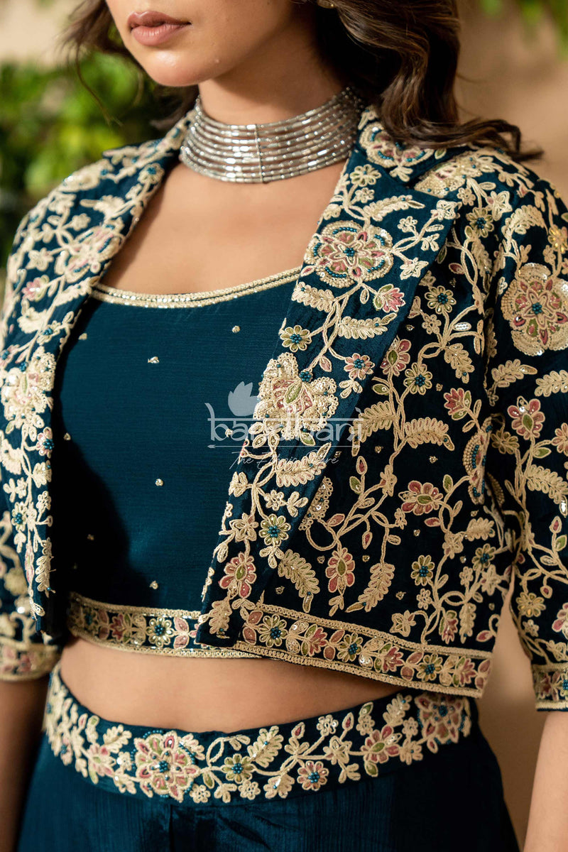 Woman wearing a dark blue embroidered blouse with a silver necklace against a blurred natural background