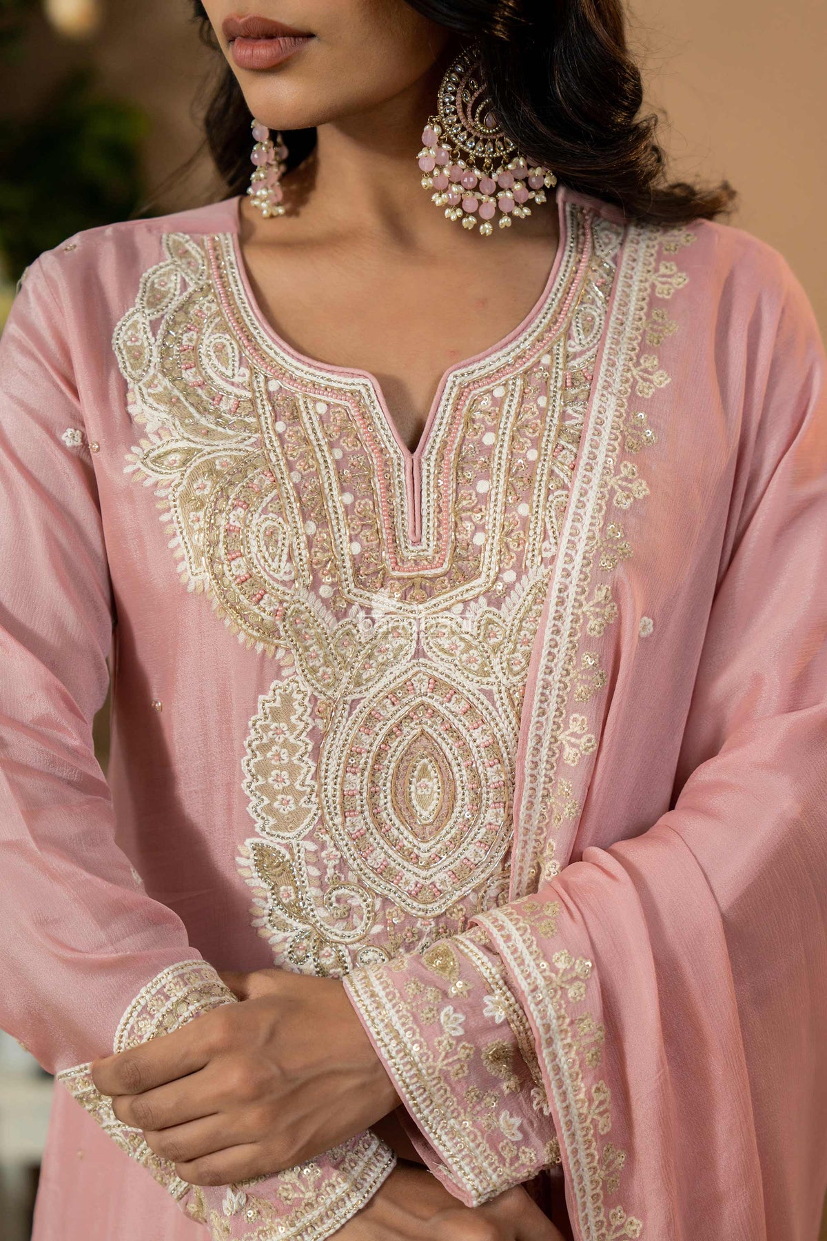Close-up of a pink embroidered garment with intricate patterns