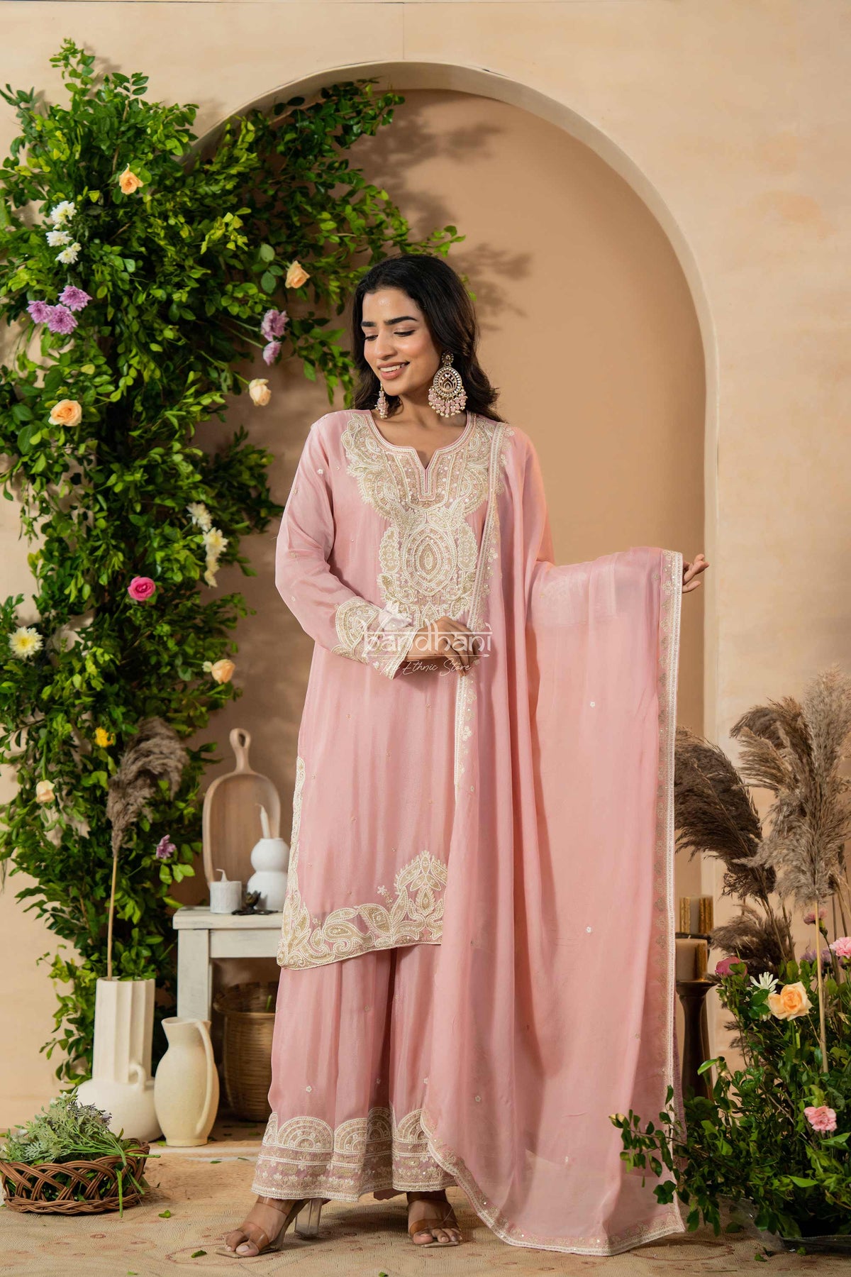 Woman in a pink traditional outfit with floral decorations in a decorated setting