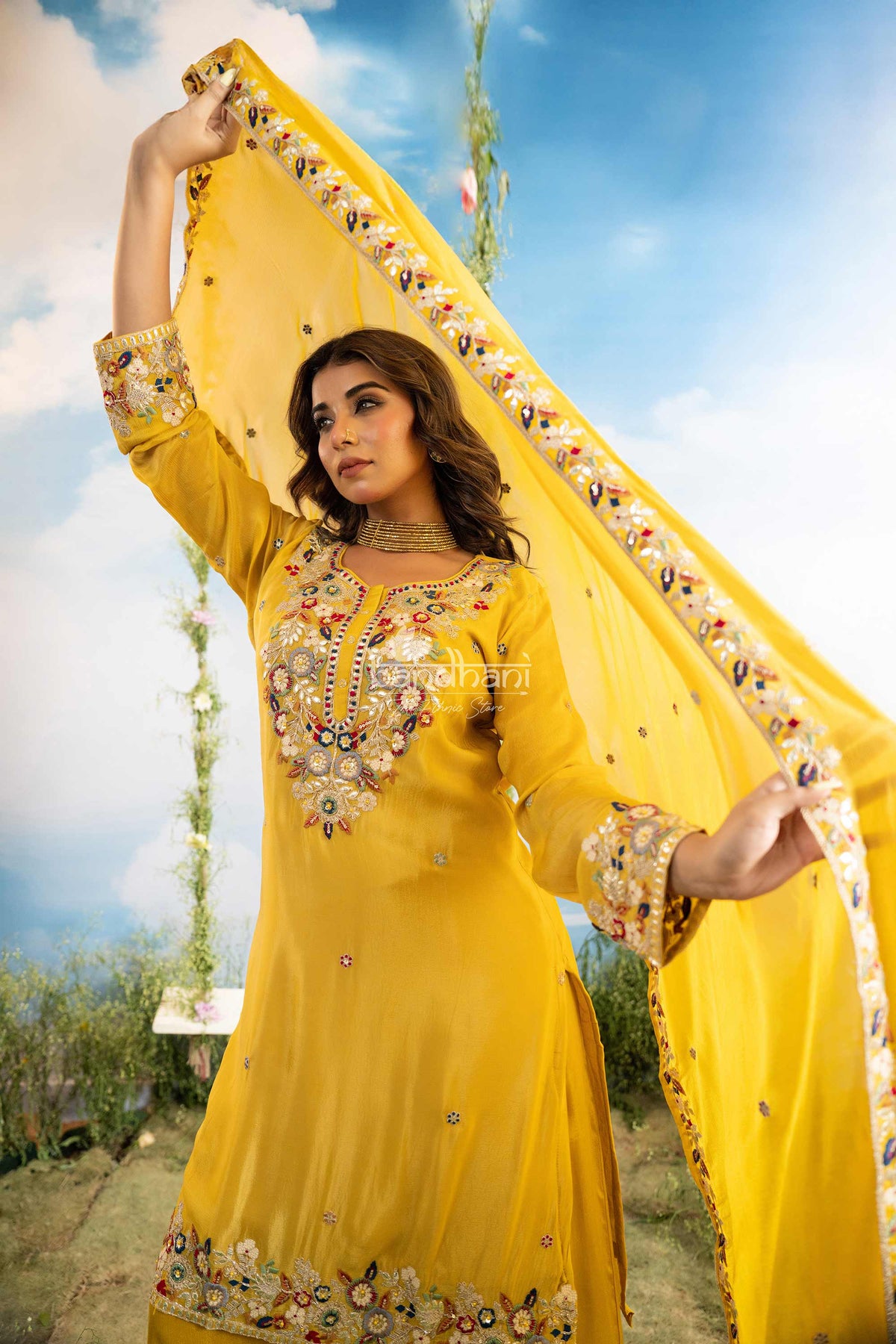 Woman in a yellow traditional outfit with floral patterns against a scenic background