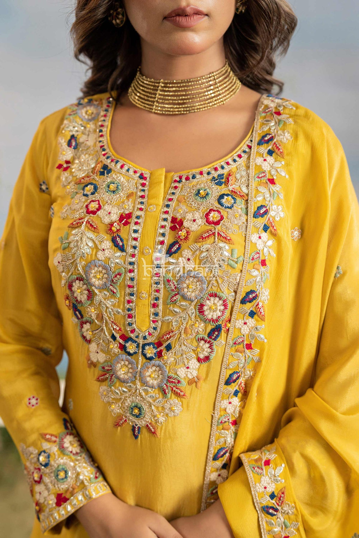 Yellow embroidered garment with intricate patterns on a blurred background