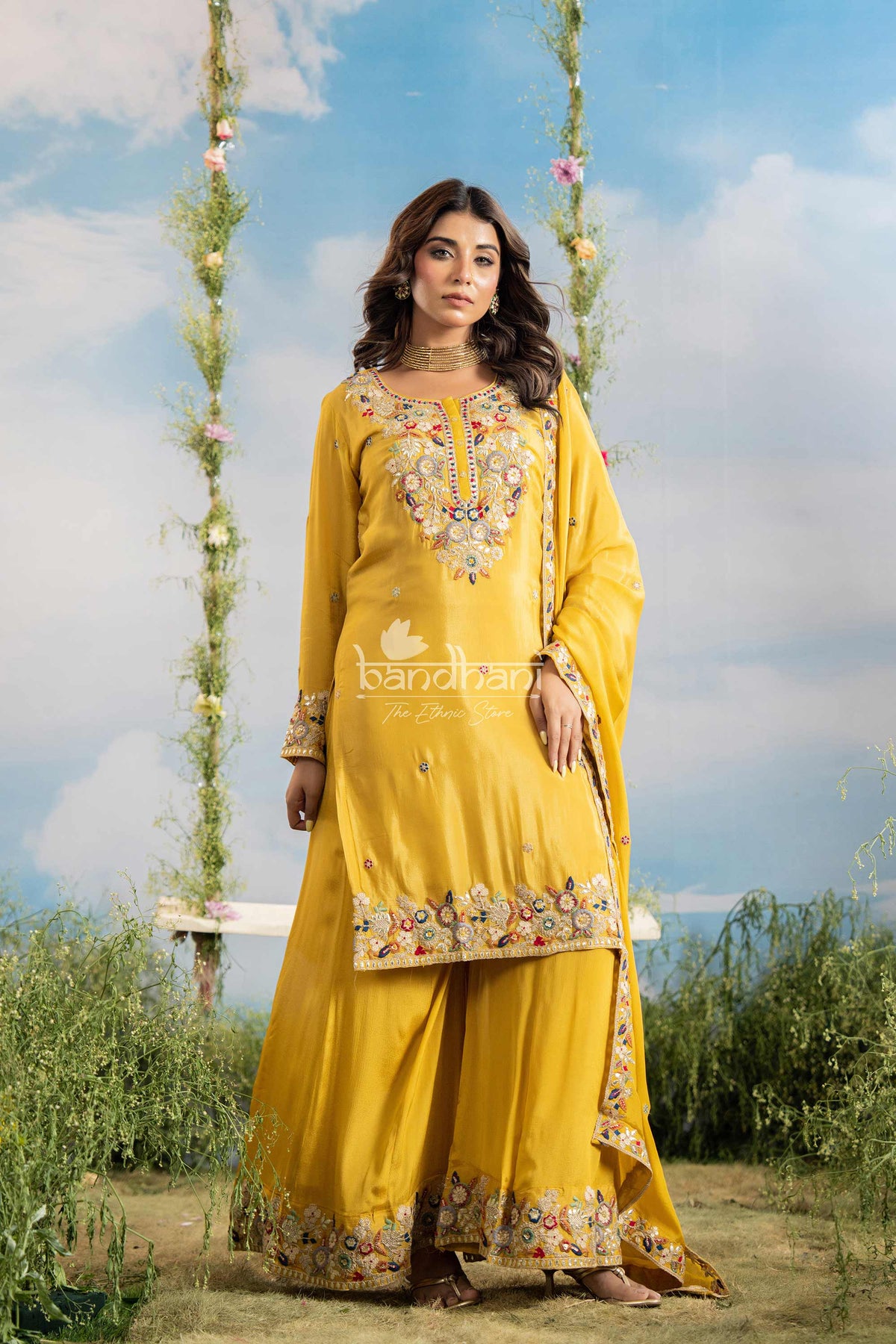 Woman in a yellow traditional outfit with floral embroidery against a scenic background