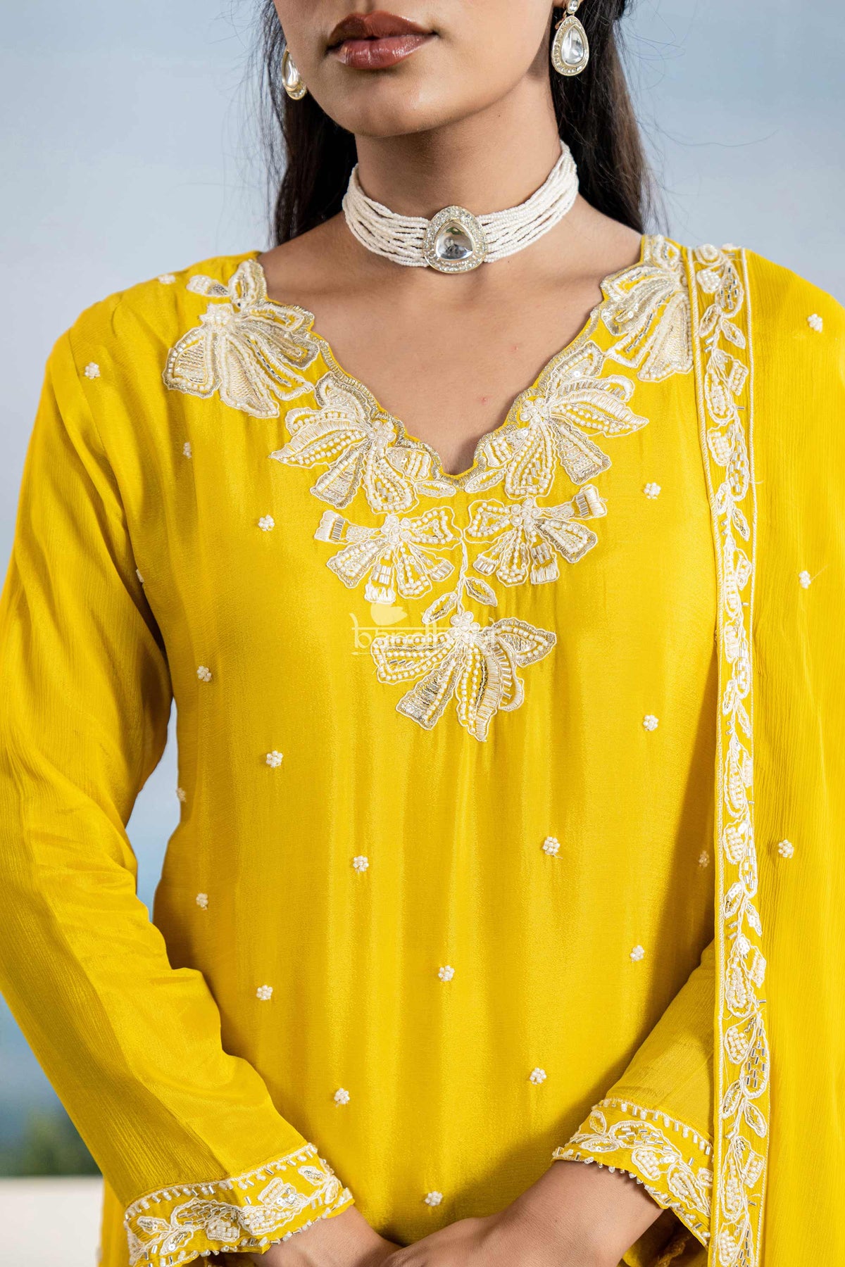 Yellow traditional outfit with white embroidery and a plain background