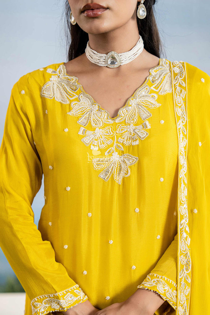 Yellow traditional outfit with white embroidery and a plain background