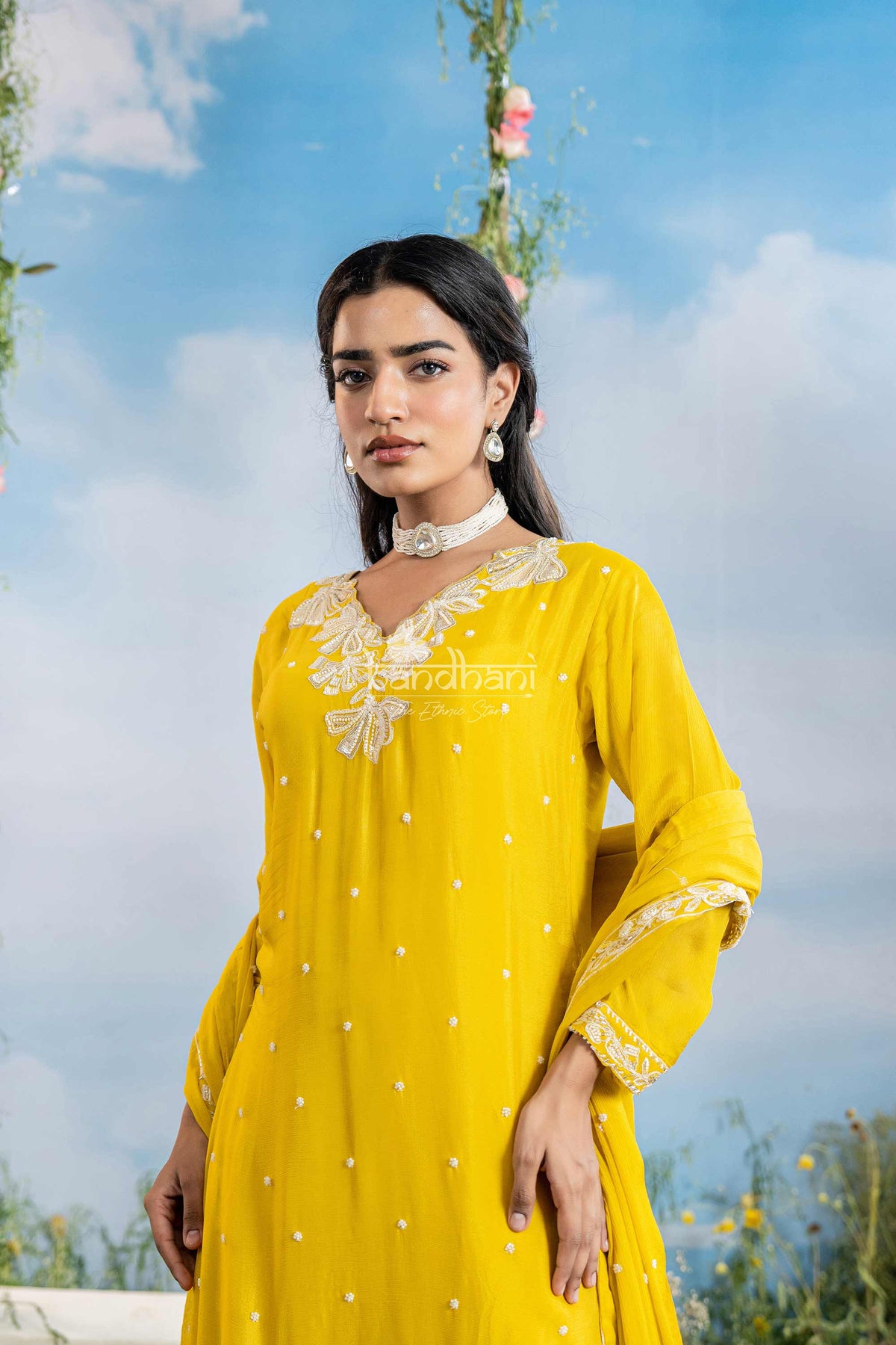 Woman wearing a yellow outfit with floral background
