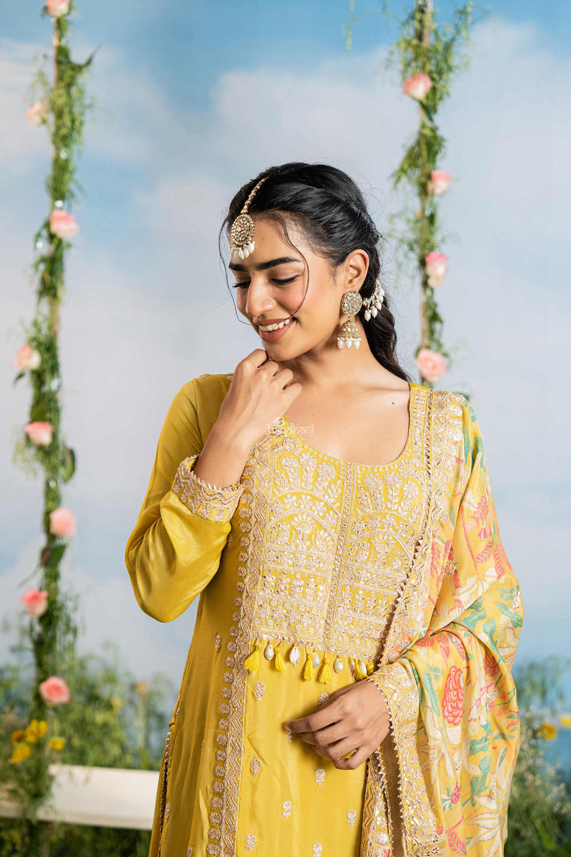 Woman in a yellow traditional outfit with floral decorations in the background