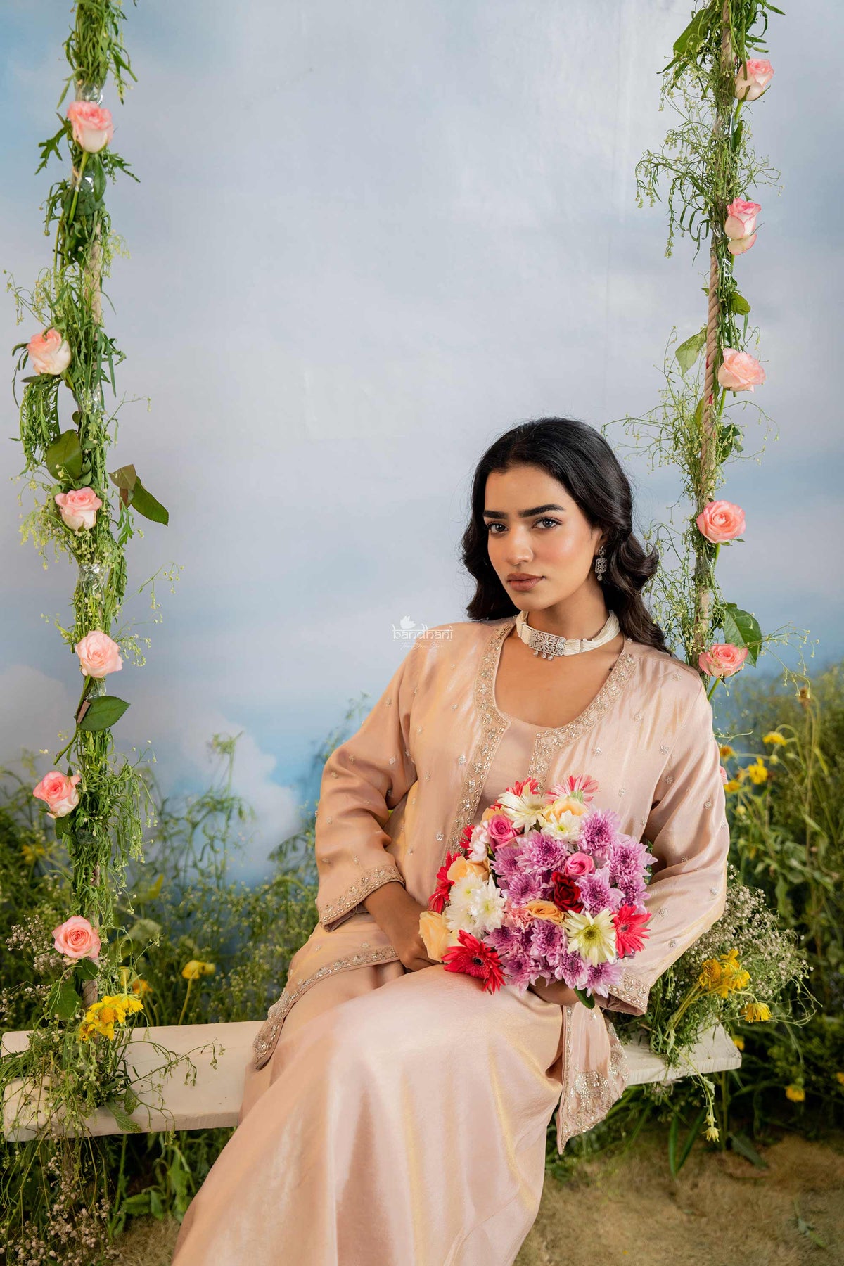 Woman sitting on a floral swing with a scenic background