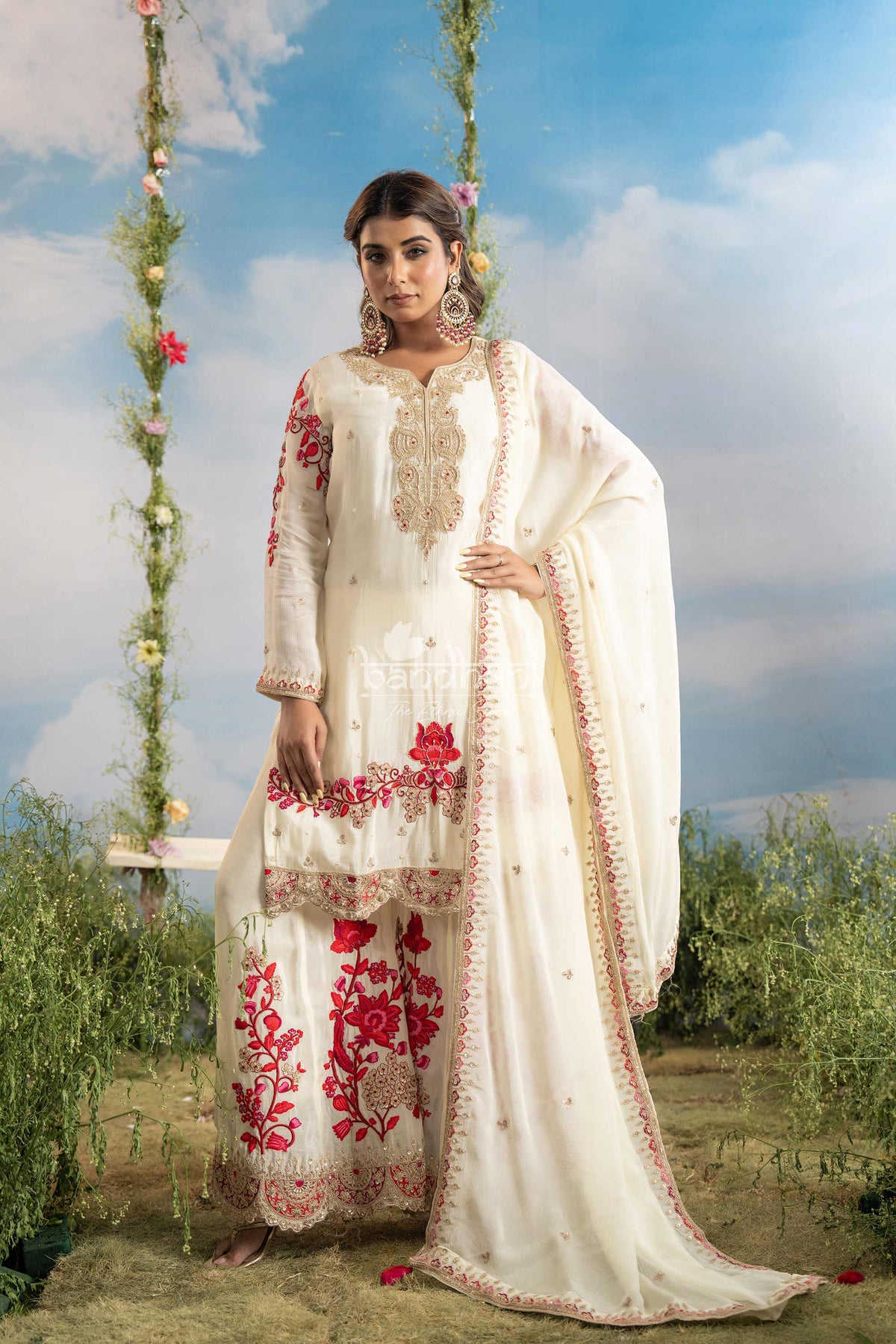 Woman in a white embroidered traditional outfit with red flowers against a natural background