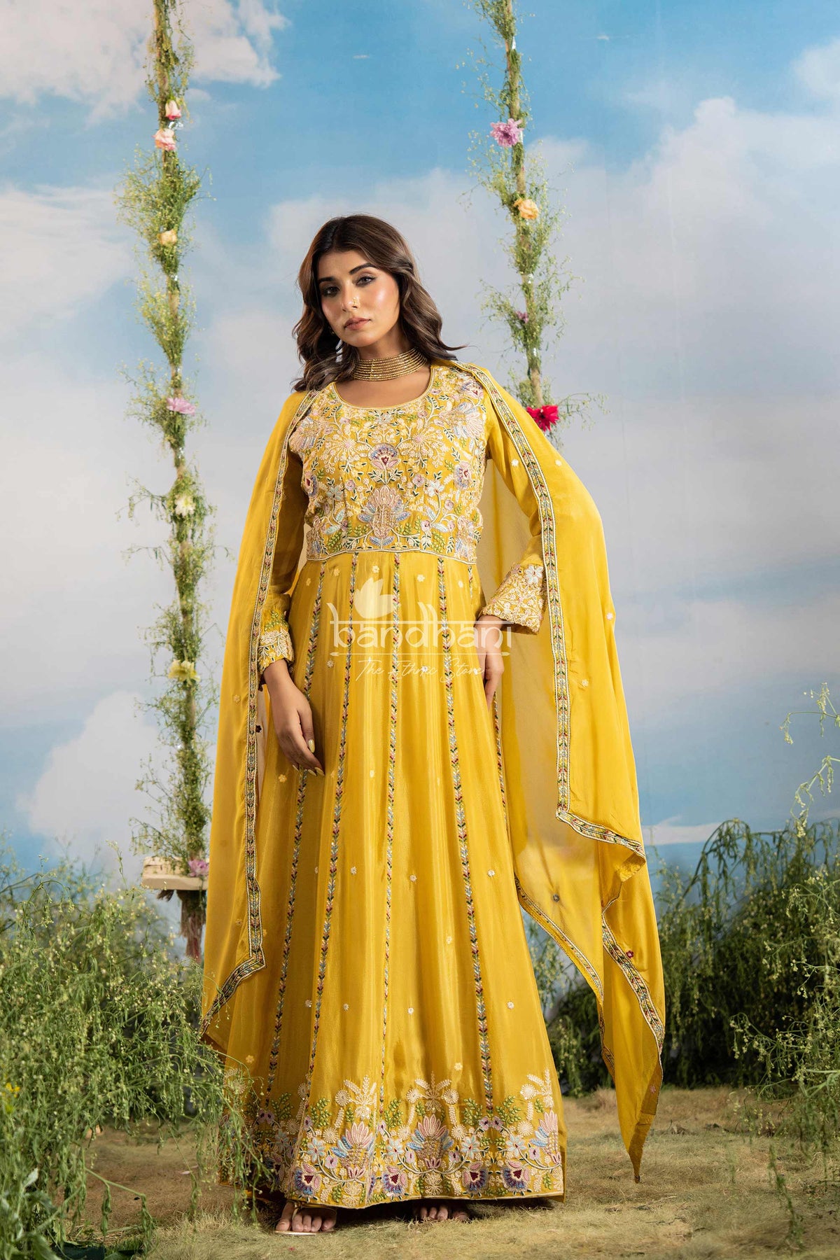 Woman in a yellow embroidered dress with a floral background