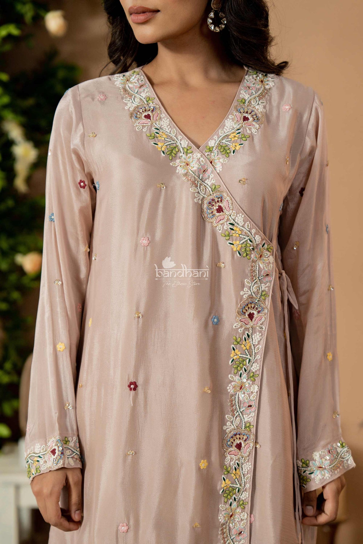 Light pink embroidered dress with floral patterns on a neutral background