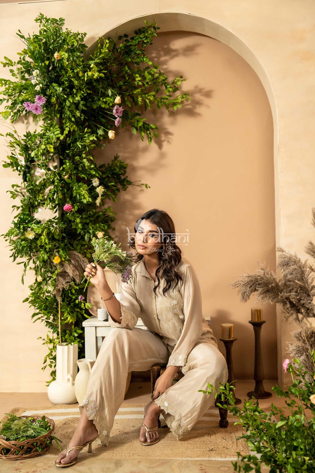 Woman sitting in a decorated room with plants and flowers