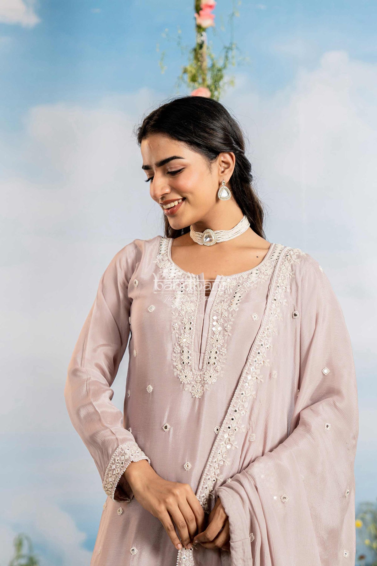 Woman in a light pink traditional outfit with floral background