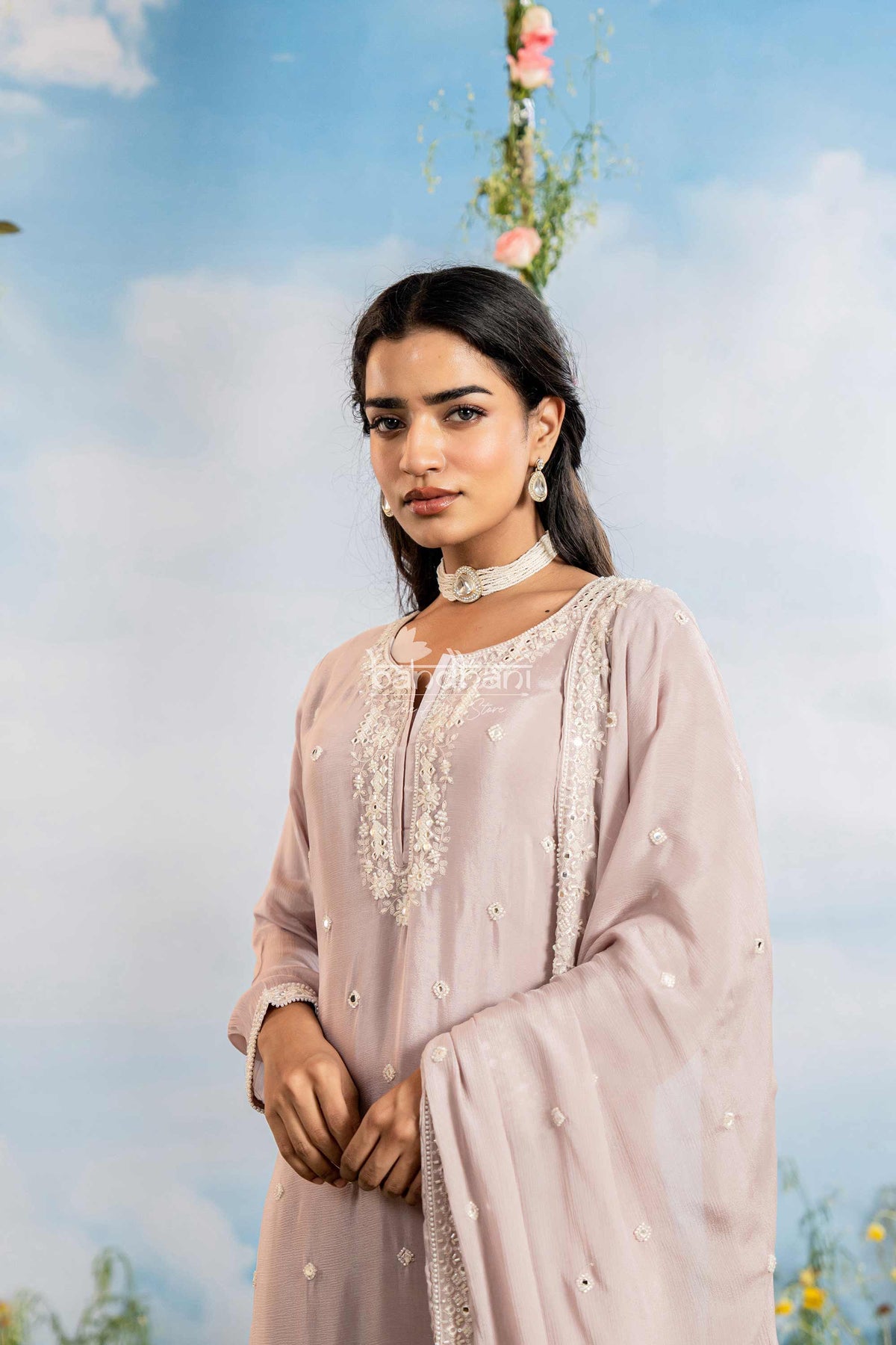 Woman in a light pink traditional outfit with floral background