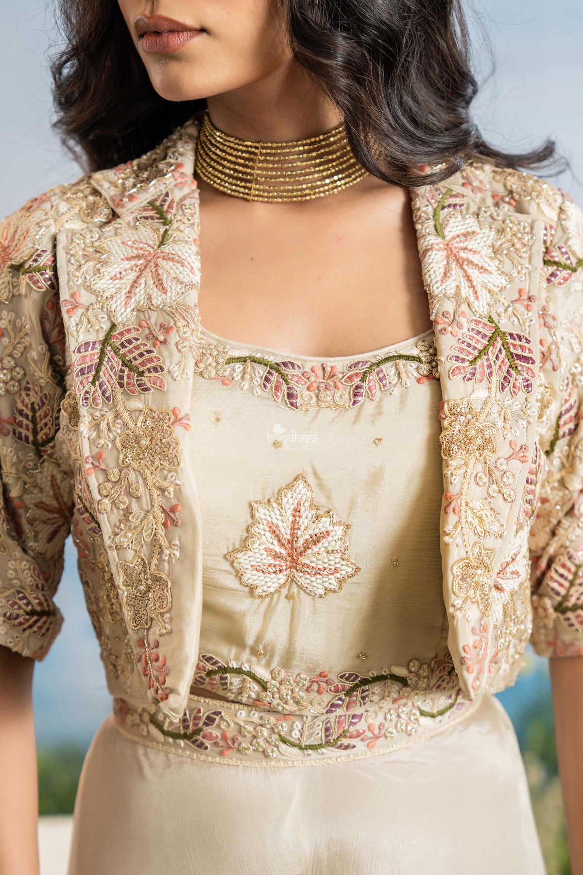 Woman wearing a traditional embroidered outfit with a floral pattern.