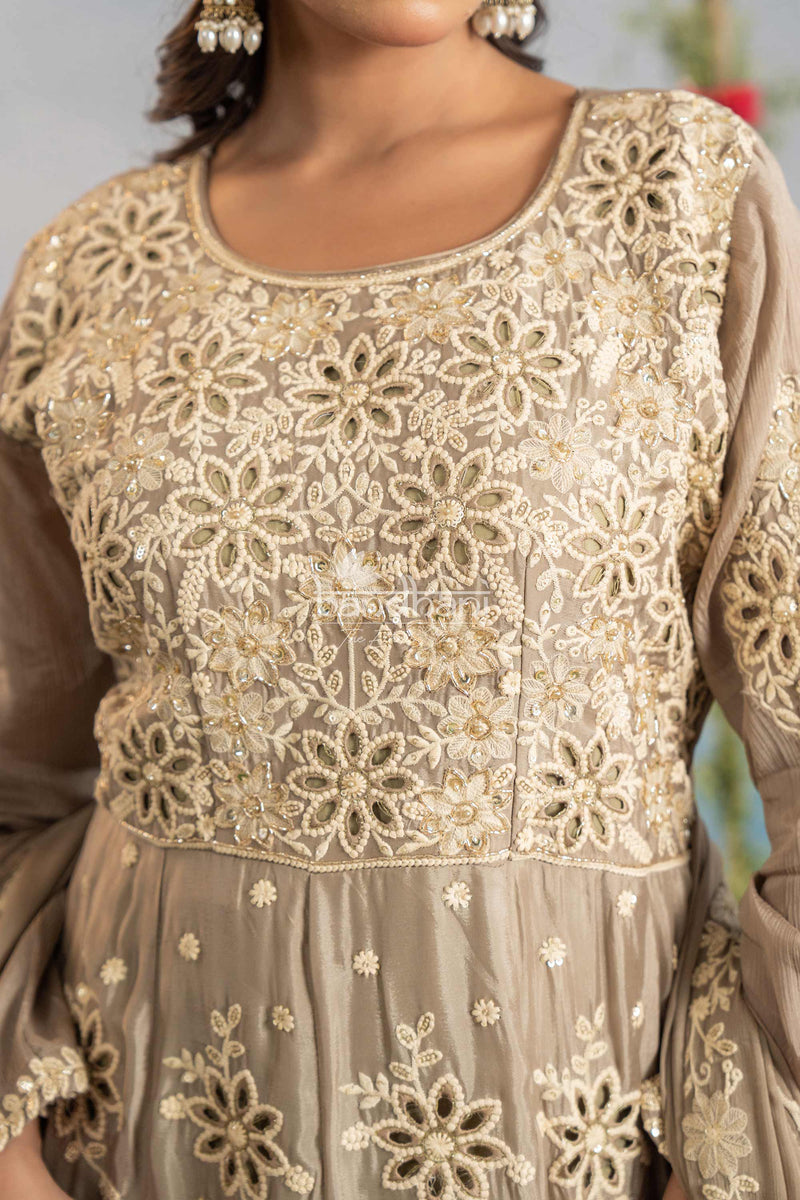 Close-up of a beige embroidered outfit with floral patterns