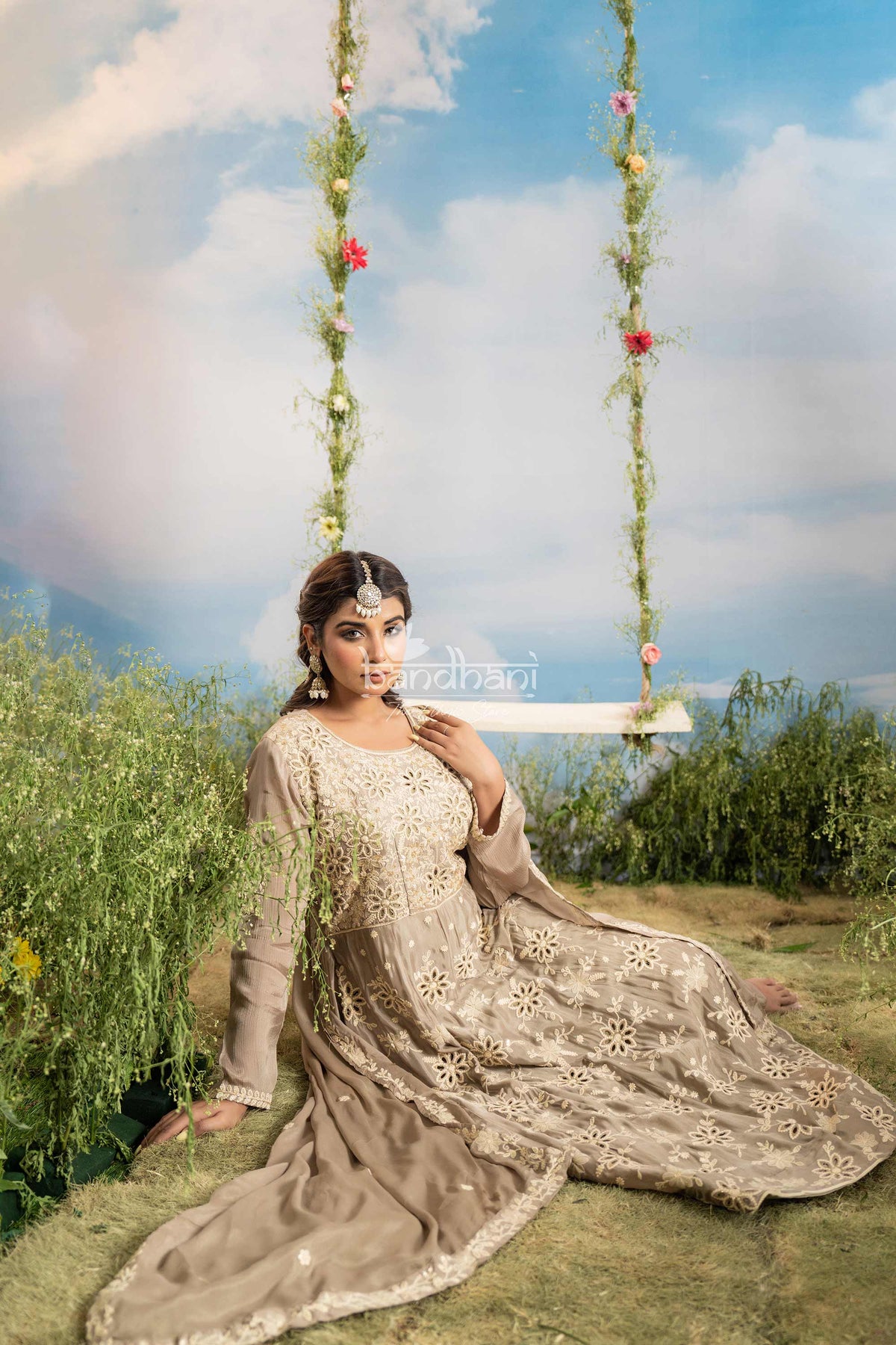 Woman in traditional attire sitting on a swing with a scenic background