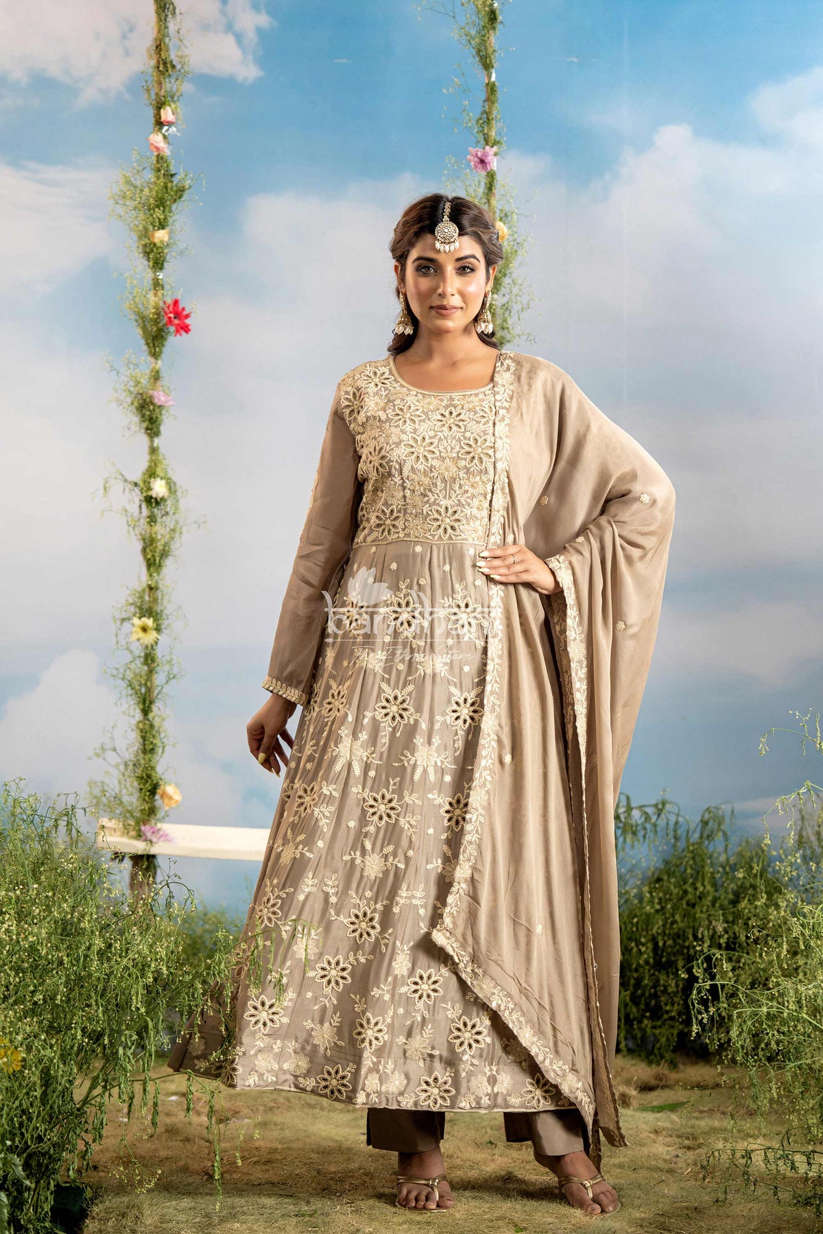 Woman in traditional attire standing outdoors with a scenic background