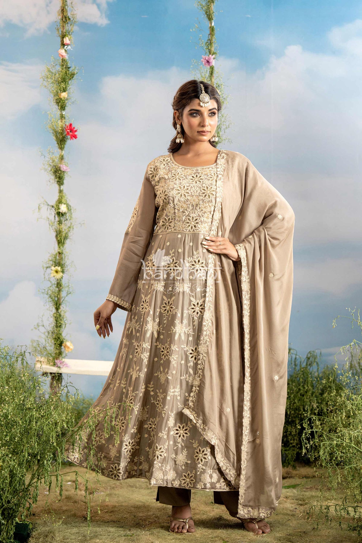 Woman in traditional attire standing outdoors with a scenic background
