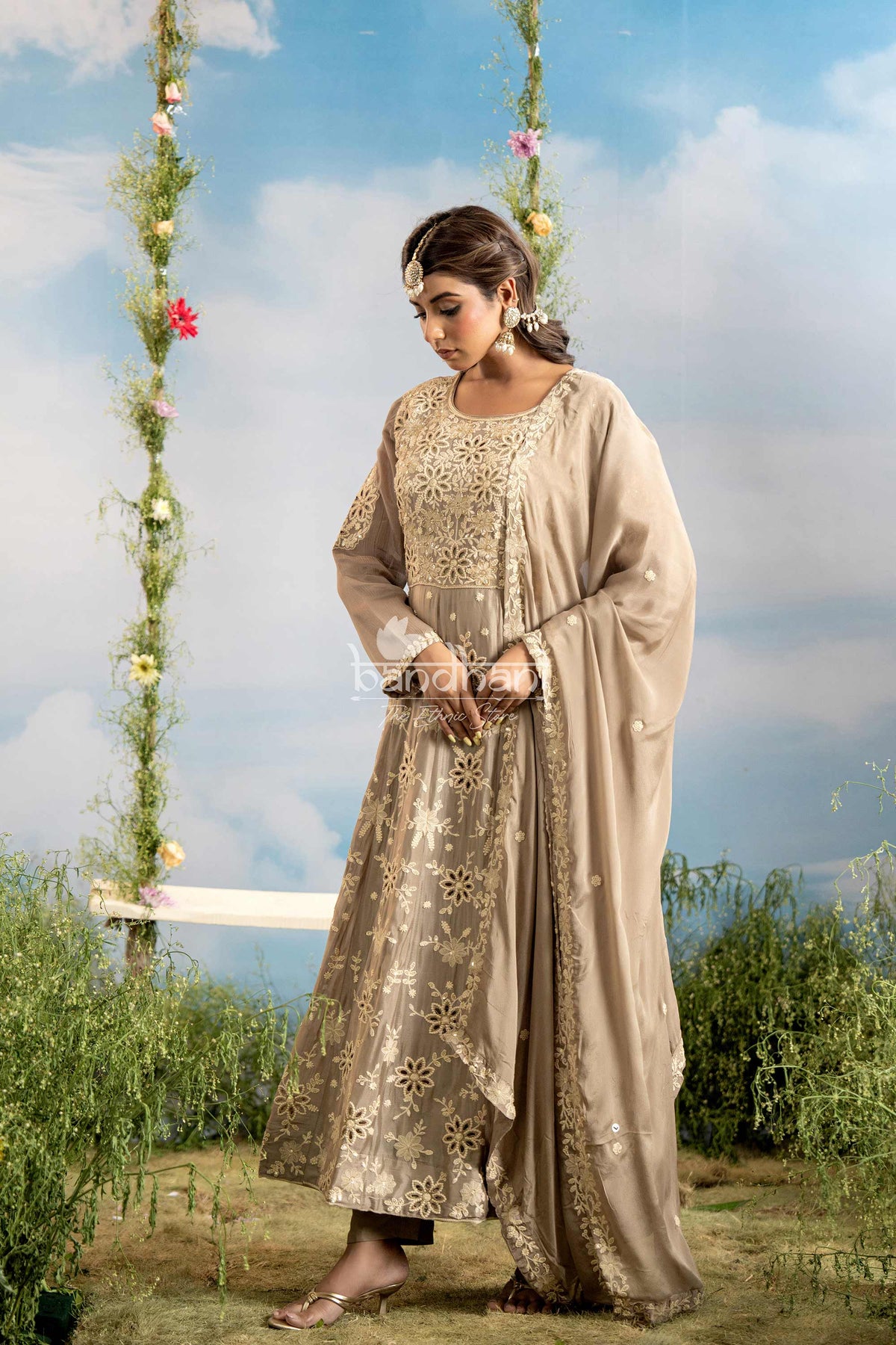 Woman in a traditional outfit standing outdoors with a scenic background