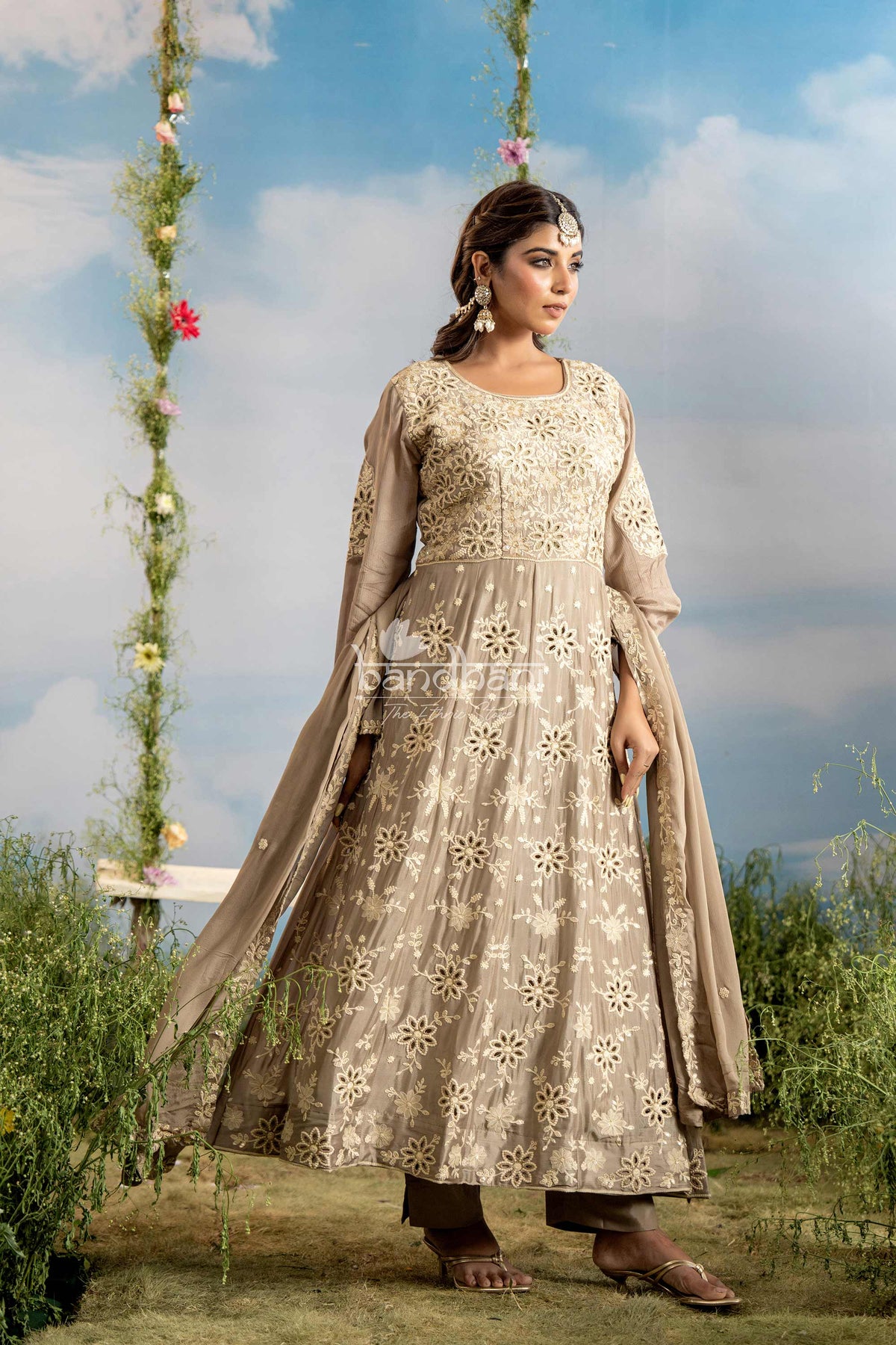 Woman in a traditional embroidered outfit standing outdoors with a scenic background