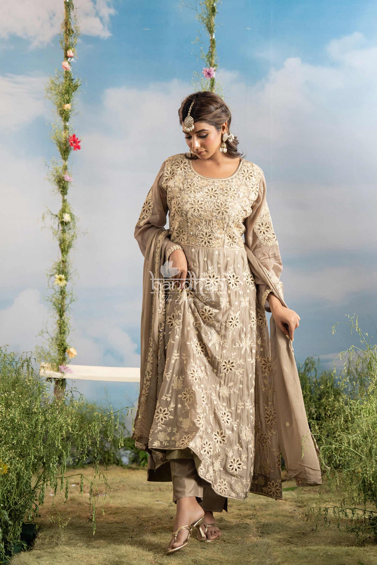 Woman in a traditional outfit standing outdoors with a scenic background