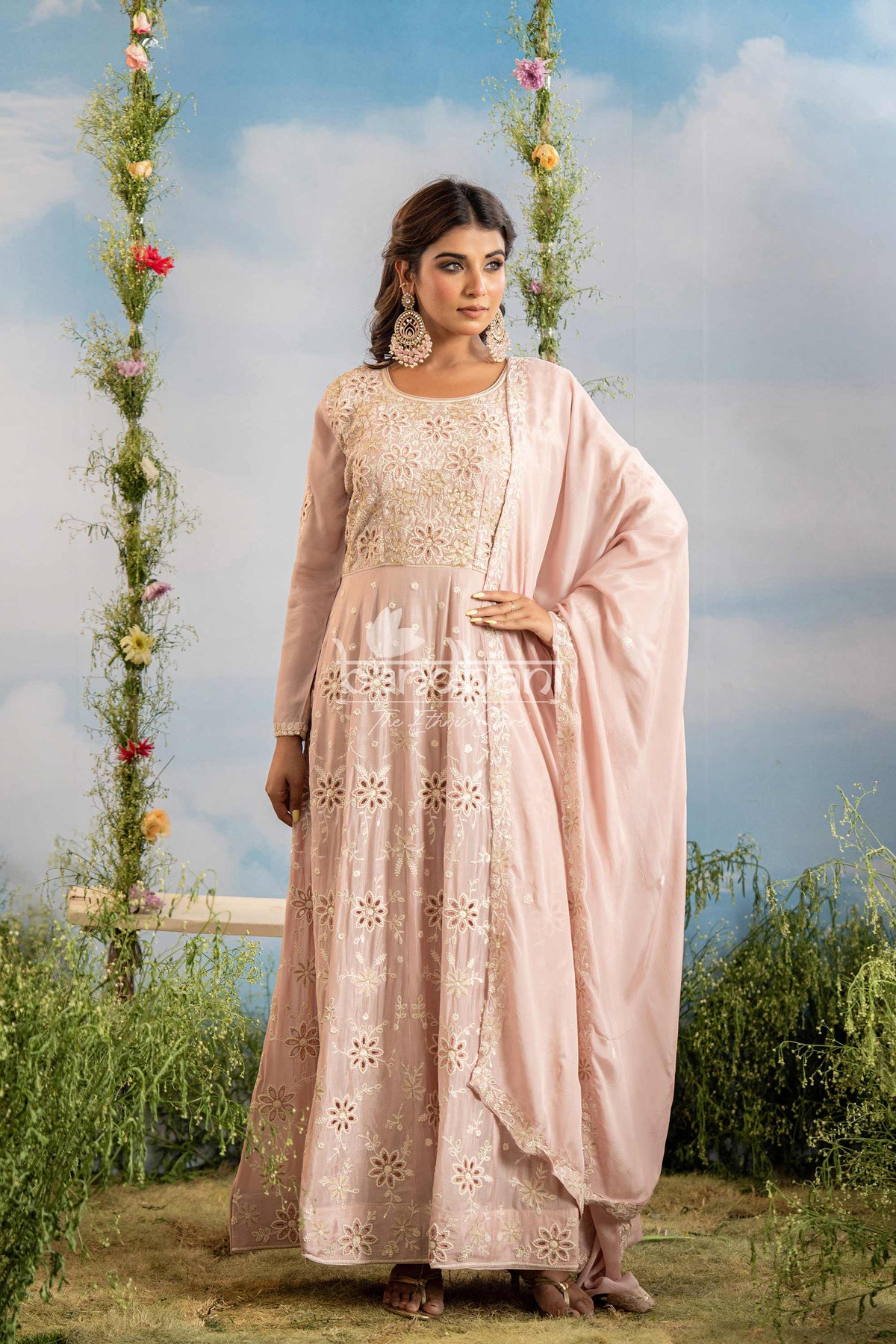 Woman in a traditional outfit with floral decorations in the background