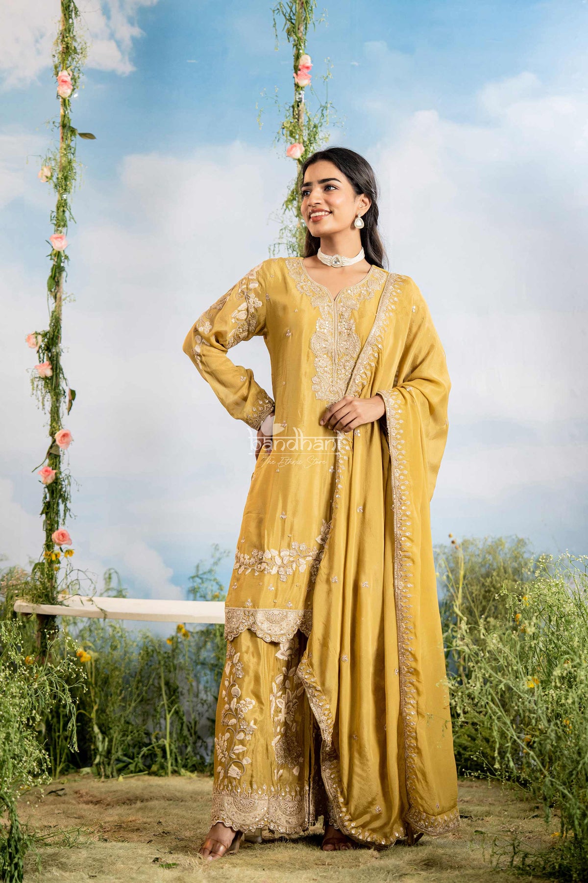 Woman in a yellow traditional outfit with floral decorations in the background