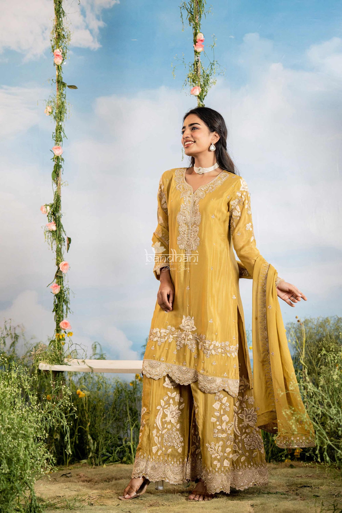 Woman in a yellow traditional outfit with floral decorations against a scenic background
