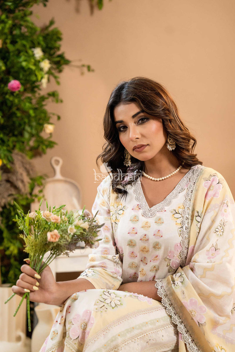 Woman in a floral saree holding flowers with a blurred background