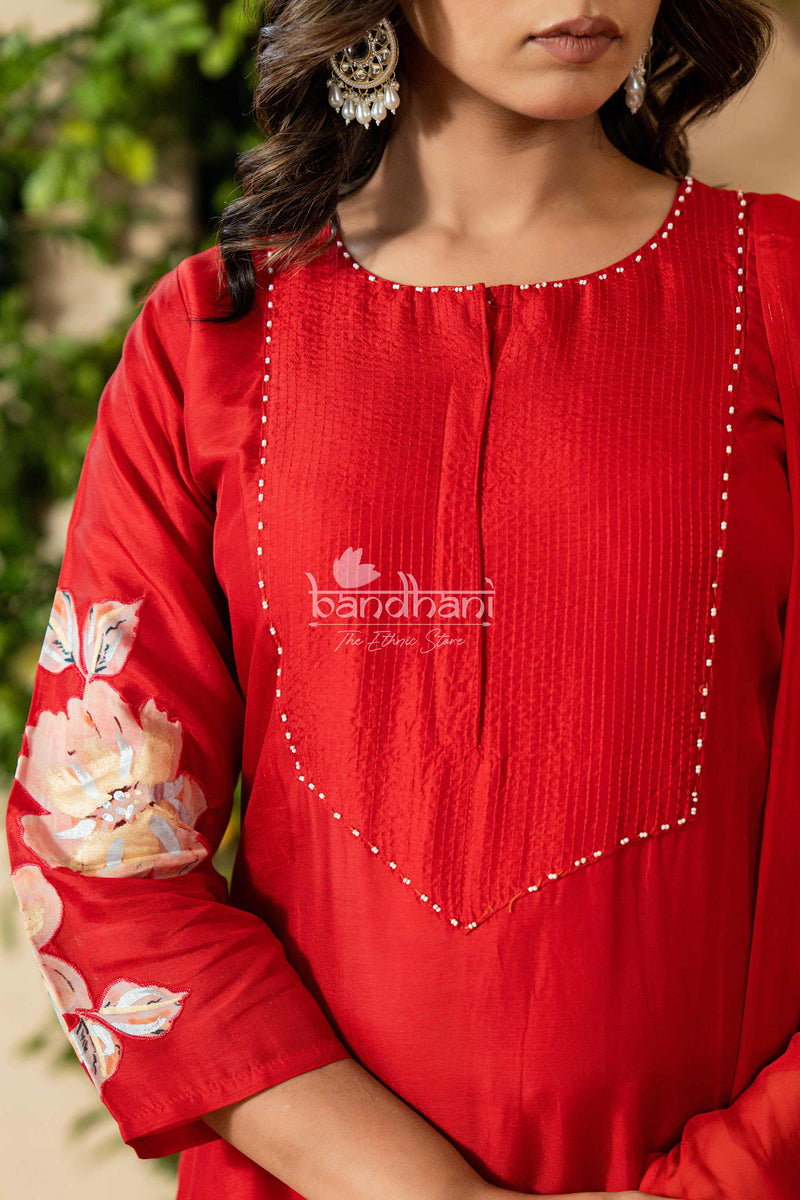 Red traditional outfit with floral embroidery and 'bandhani' branding.