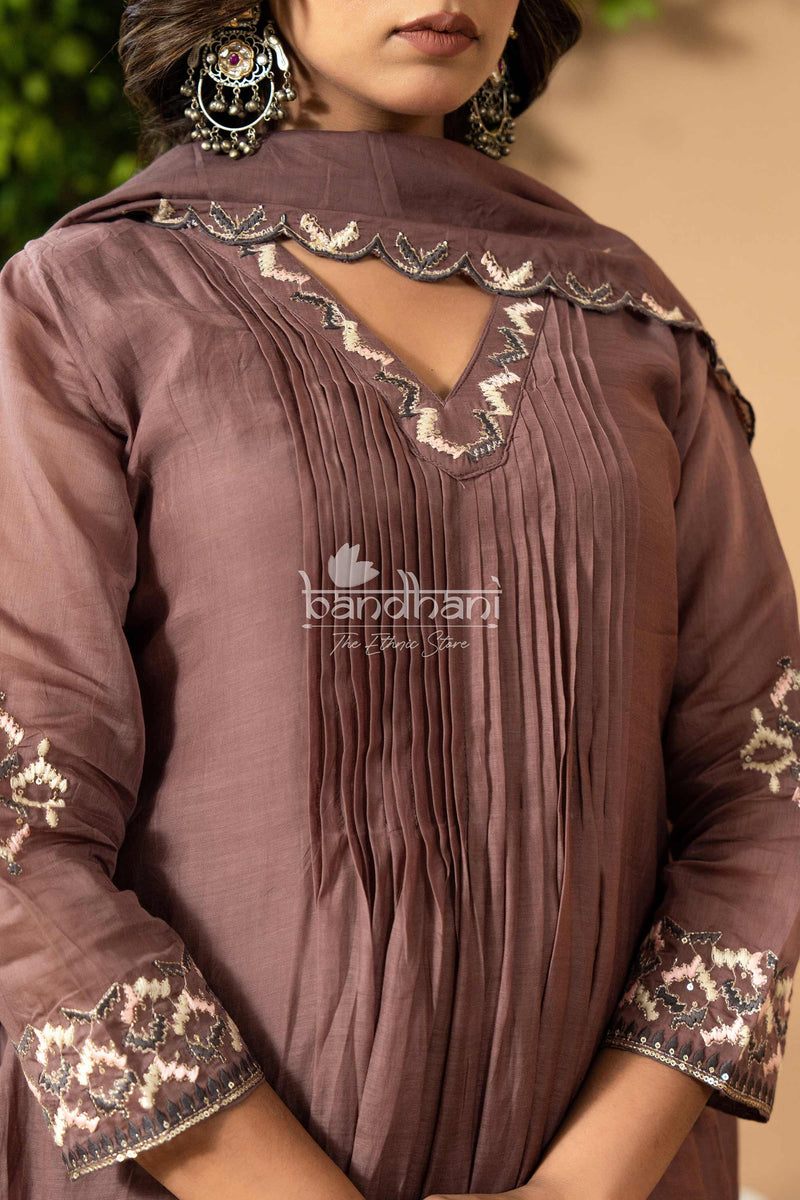 Brown traditional outfit with intricate embroidery and fringes, featuring the brand 'Bandhani'.