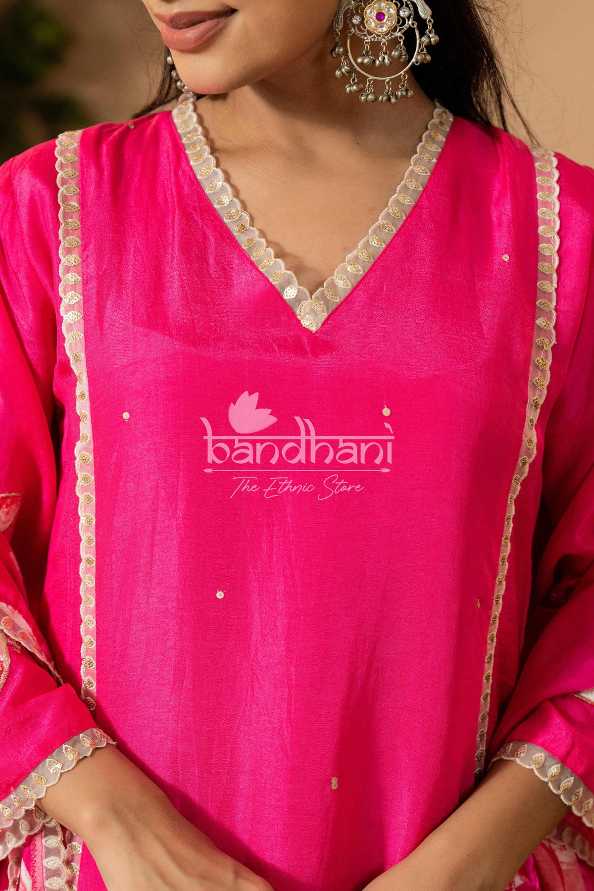 Pink traditional outfit with 'bandhani' branding on a blurred background