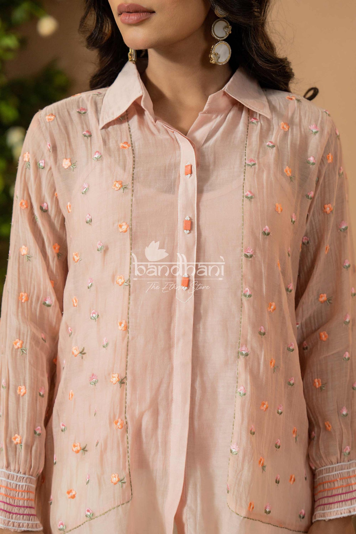 Light pink embroidered shirt worn by a person, with 'bandhani' branding visible.